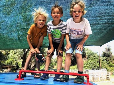 Kinder spielen auf Holzboot im Garten des Honigtals